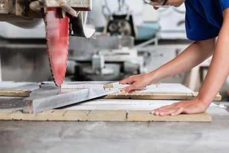 Stone mason woman measuring stone plate for sawing in workshopの写真素材