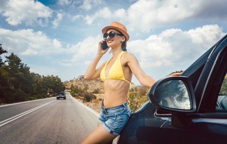 Woman using phone in her vacation to call friendsの写真素材