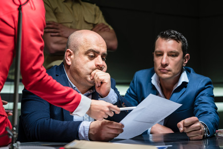 Portrait of a middle-aged man calling his attorney in order to ask for legal assistance, under the pressure of a difficult interrogation at the policeの写真素材