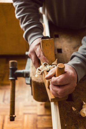 Top view of carpenter hand working with wood planer in his carpentry workshopの写真素材