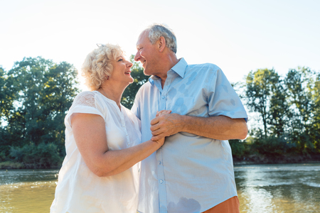 Low-angle side view portrait of a romantic senior couple in love enjoying a healthy and active lifestyle outdoors in summerの写真素材