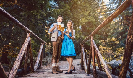Woman and man with beer and pretzel standing on bridge in Bavariaの写真素材