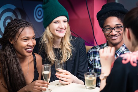 Group of multi ethnic friends enjoying drinks in the restaurant