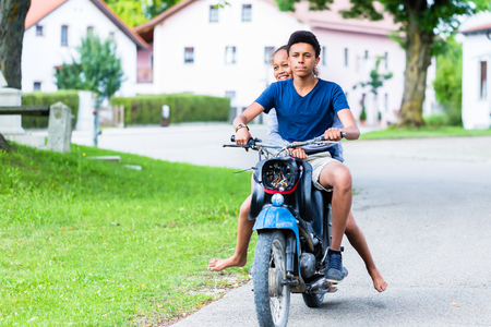 Happy brother and sister enjoying the ride on motorbikeの写真素材