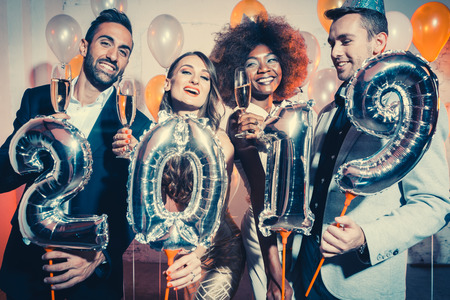 Party people women and men celebrating new years eve 2019 with sparklers and Champagne