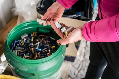 Batteries being disposed of in recycling center, hands of woman