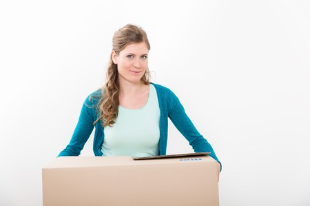 Portrait of smiling young woman holding cardboard box isolated over white background