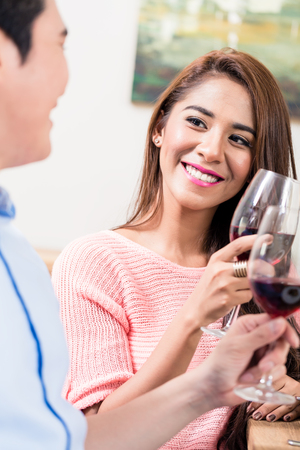 Portrait of smiling woman toasting wine glasses with her boyfriendの写真素材