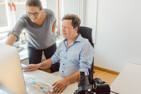 Woman and man working on a video in post-production on the computerの写真素材