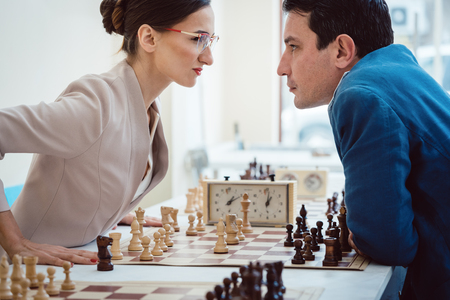Concept of confrontation, businesspeople playing chess looking at each other with aggressionの写真素材