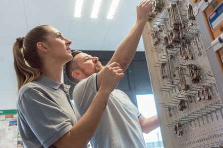 Man and woman key maker in their shop choosing blanks