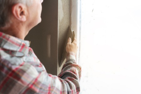 Diligent plasterer working on a window openingの写真素材