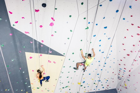 Man and woman getting training of climbing wallの写真素材