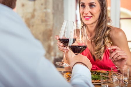 Young couple on a date toasting glass of wineの写真素材