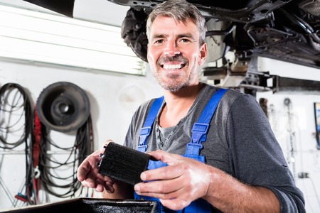 Professional smiling car mechanic working in an auto repair serviceの写真素材