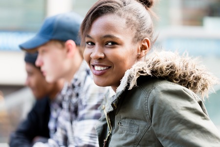 Close-up of happy girl sitting with her friends