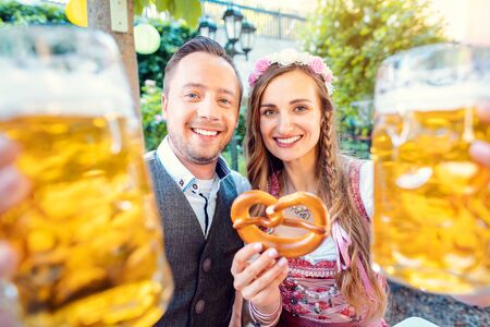 Couple of woman and man in Bavaria enjoying a beer in a traditional pubの写真素材