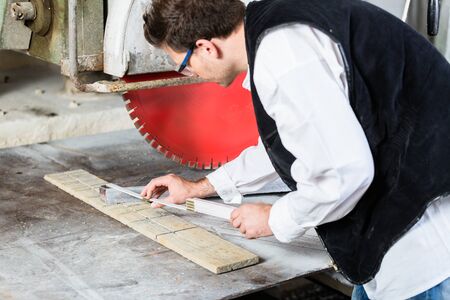 Handyman in stone carving factory working at diamond saw
