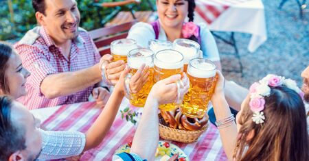People enjoying food and drink in Bavarian beer garden on a sunny dayの写真素材