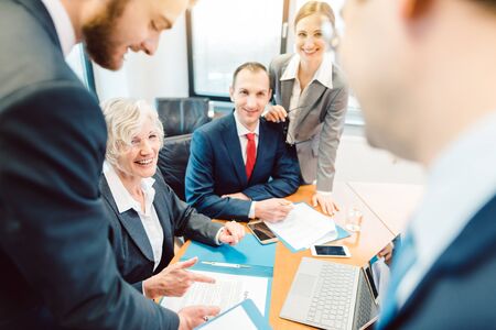 Team of motivated business people driving a project forward, mixed senior and junior women and men