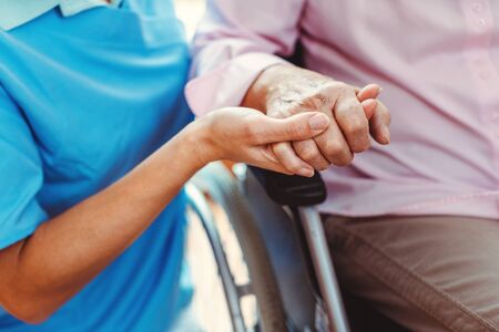 Nurse consoling a senior woman in the nursing home holding her hand in the nursing homeの写真素材