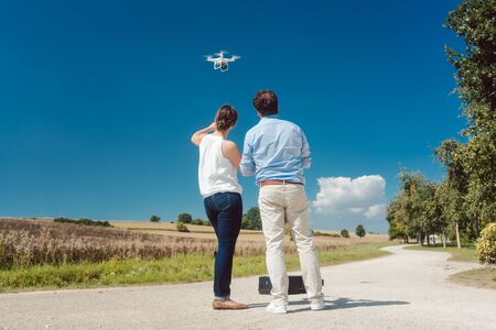 Crew or man and woman operating a drone to utilize it for a photo or film shootの写真素材