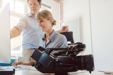 Woman and man working on a video in post-production on the computer