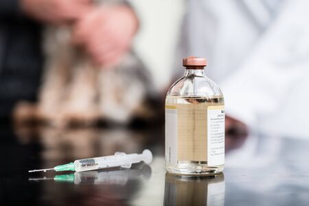 Close-up of syringe and injection solution bottle