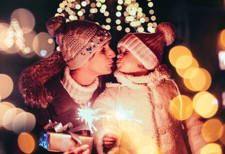 Mother and daughter on the Christmas market with lights