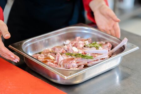 A chef preparing a lamb steak with rosemary for cookingの写真素材