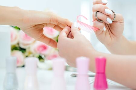 Nails of woman being prepared for manicure with brushの写真素材
