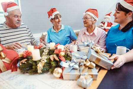 Christmas with presents in the nursing home, seniors and nurses celebrating together