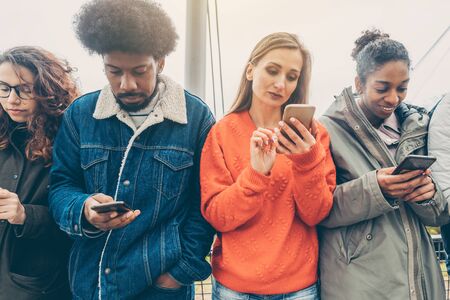 Group of people choosing their phones over personal interactionの写真素材