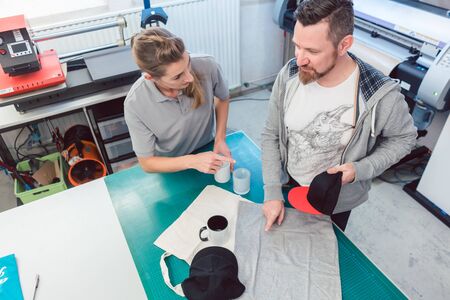 Man and woman discussing which promotional items to use in creative brainstorm