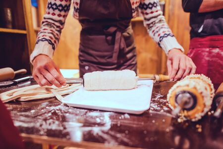 Woman baker on Christmas market making traditional sweet cakesの写真素材