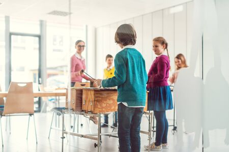 Music teacher with students in class playing the xylophoneの写真素材