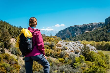 Woman making rest from hiking watching the hills, nature, and beautiful scenery in spring