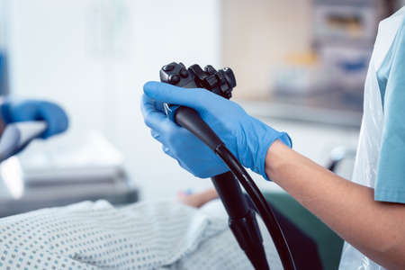 Doctor proctologist holding endoscope during colonoscopy