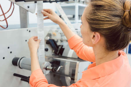 Worker at Quality control in the label printing shop