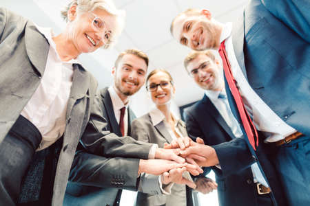 Business Team stacking hands looking at camera traying to lure in new job applicants