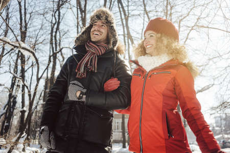 Couple having a walk through the woods in winter on a cold day