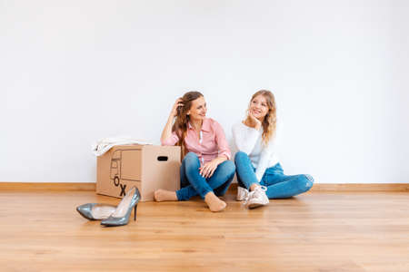 Two women in new apartment dreaming of how to decorate it after moving inの写真素材