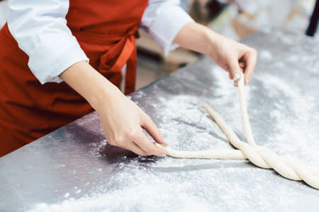 Baker showing sheet with bread ready to be baked into the camera