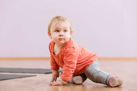 Toddler sitting on floor in gymの写真素材
