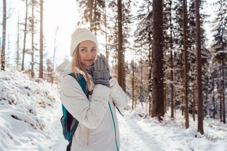 Woman enjoying her winter hike enjoying the sunset in the forestの写真素材