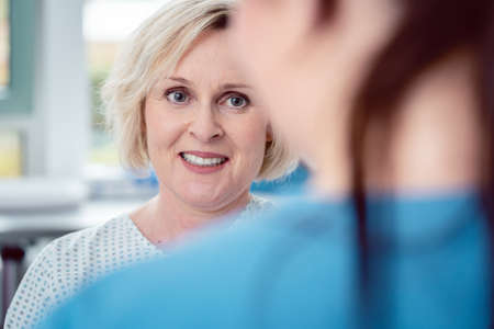 Nurse preparing patient for the coming surgery by explaining what will happenの写真素材