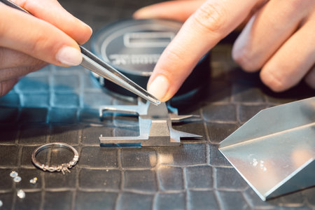 Close-up of jeweler sorting pure diamonds on her workbenchの写真素材