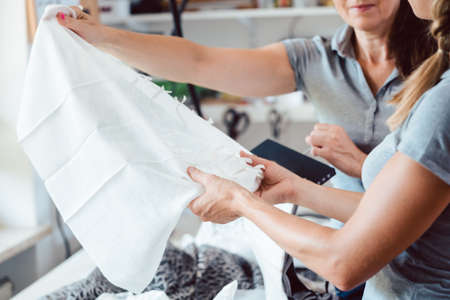 Designers inspecting sample fabric with their hands in a studioの写真素材