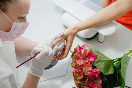 Nail artist working with a woman client, seen from aboveの写真素材
