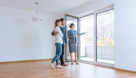 Young couple getting tour through apartment they consider renting or purchasingの写真素材